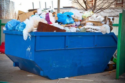 Workers loading a skip with waste
